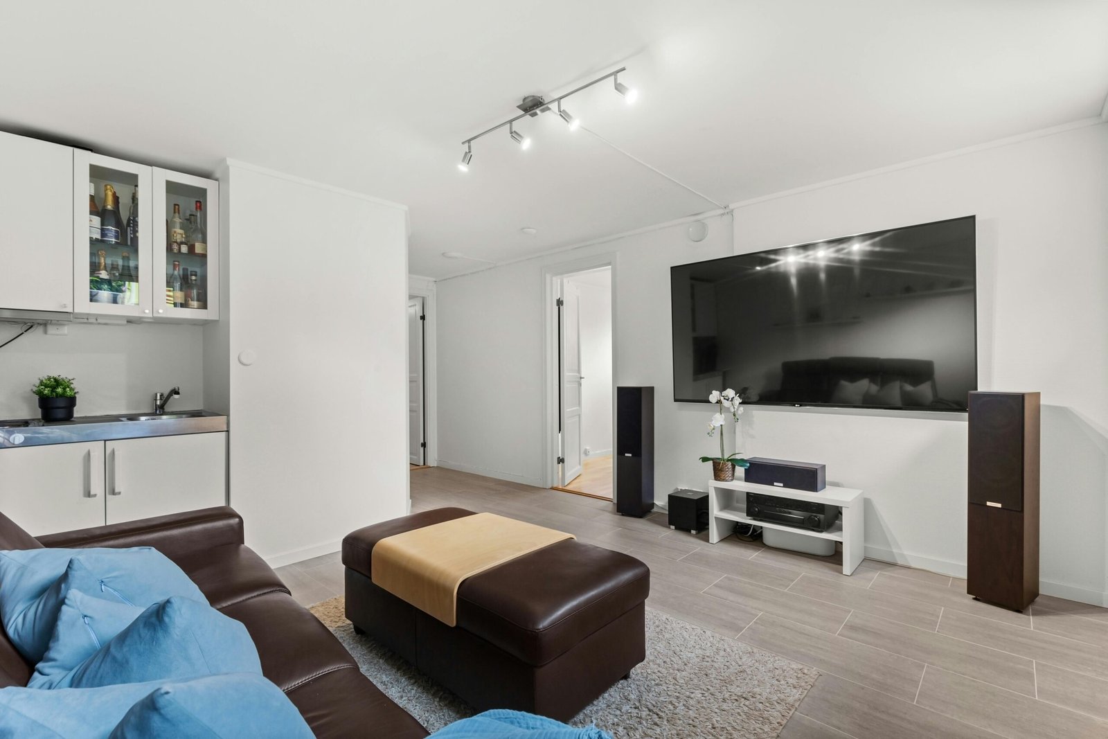 A sleek modern living room featuring smart speakers and automated lighting.