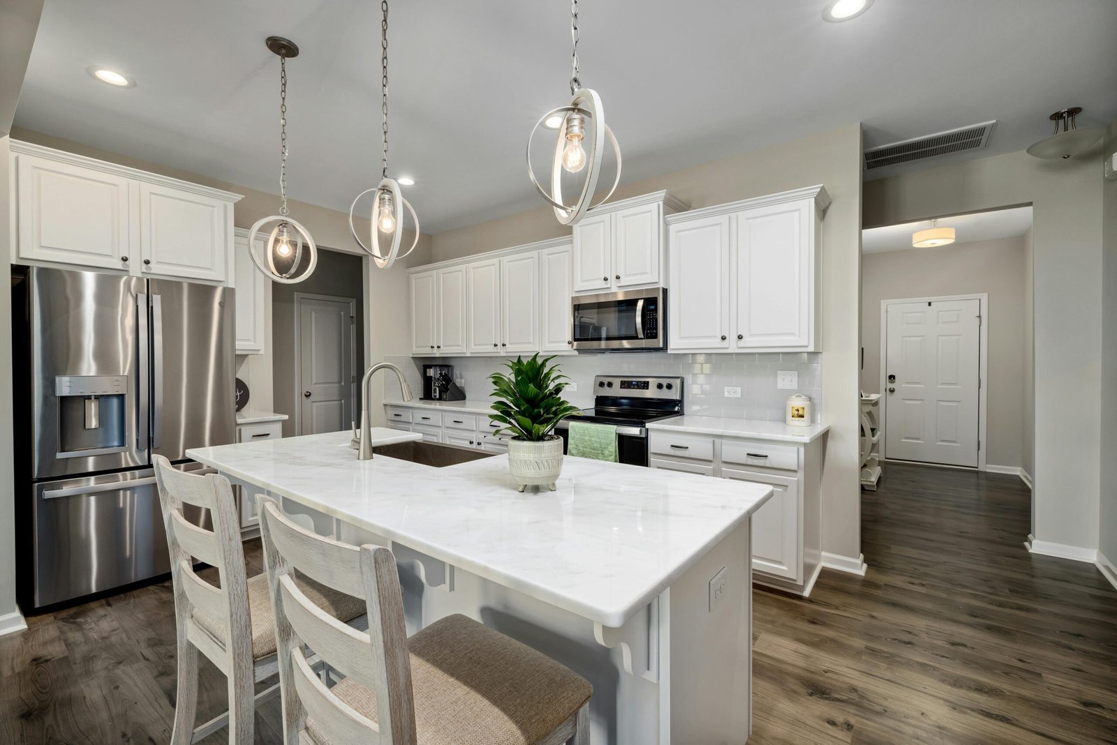 An open-plan kitchen area with marble countertops, stainless steel appliances, and minimal accessories